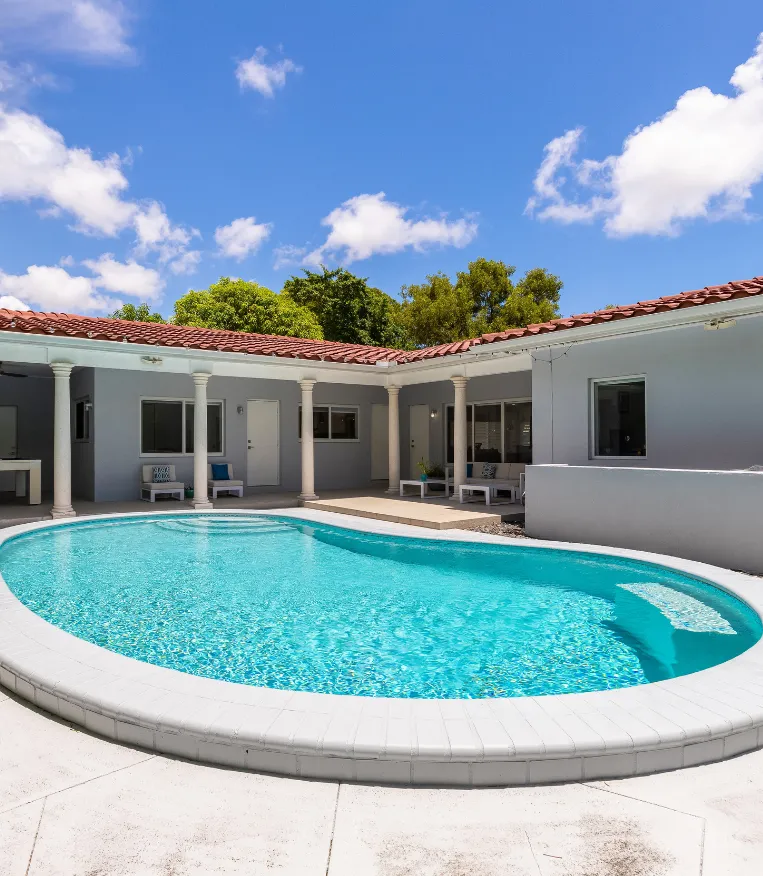 Luxury residential pool with curved design and white patio in Dallas, TX – Dallas Pools Contractor