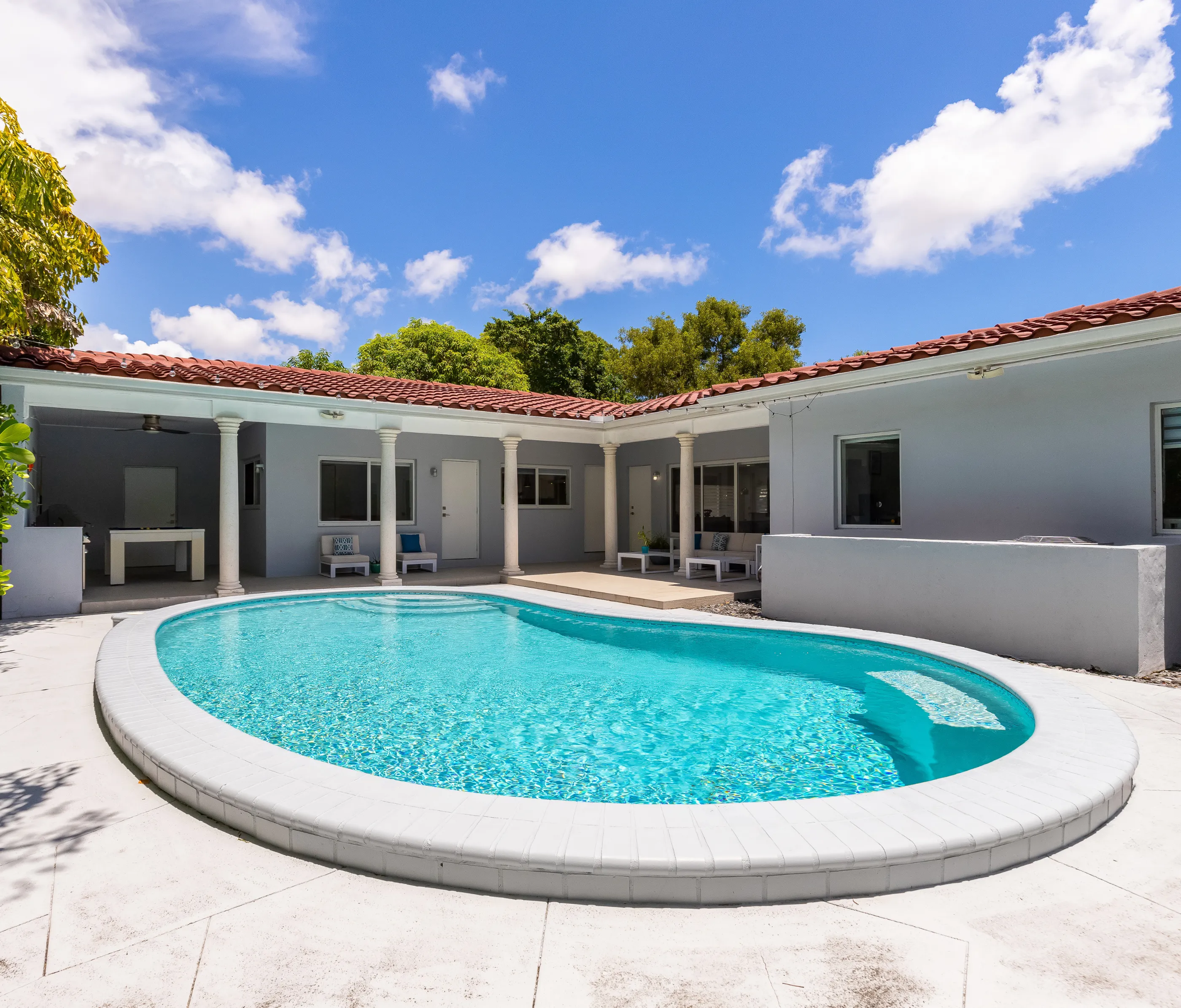 Luxury residential pool with curved design and white patio in a Dallas home – Dallas Pools Contractor