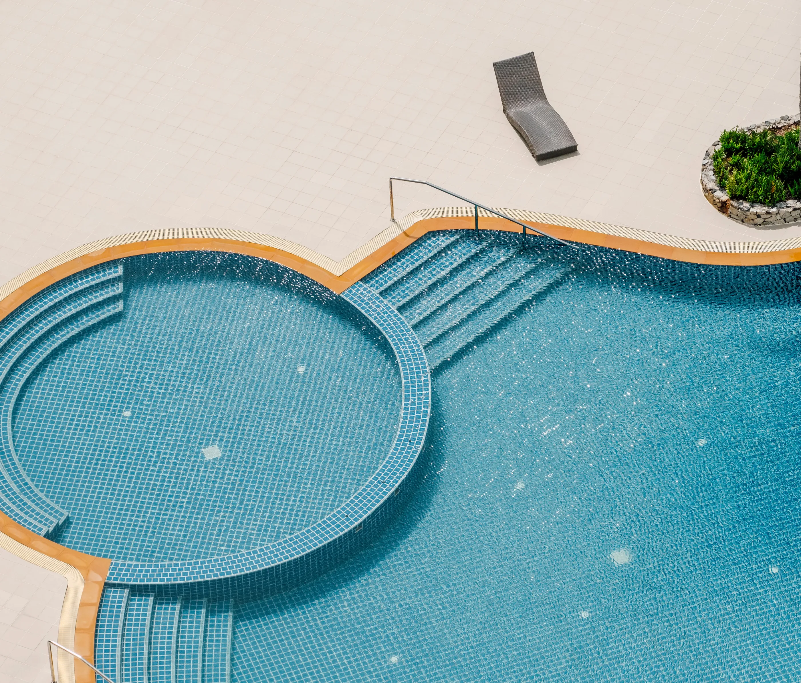 Top view of round tiled pool with built-in steps and sun lounger – Dallas Pools Contractor
