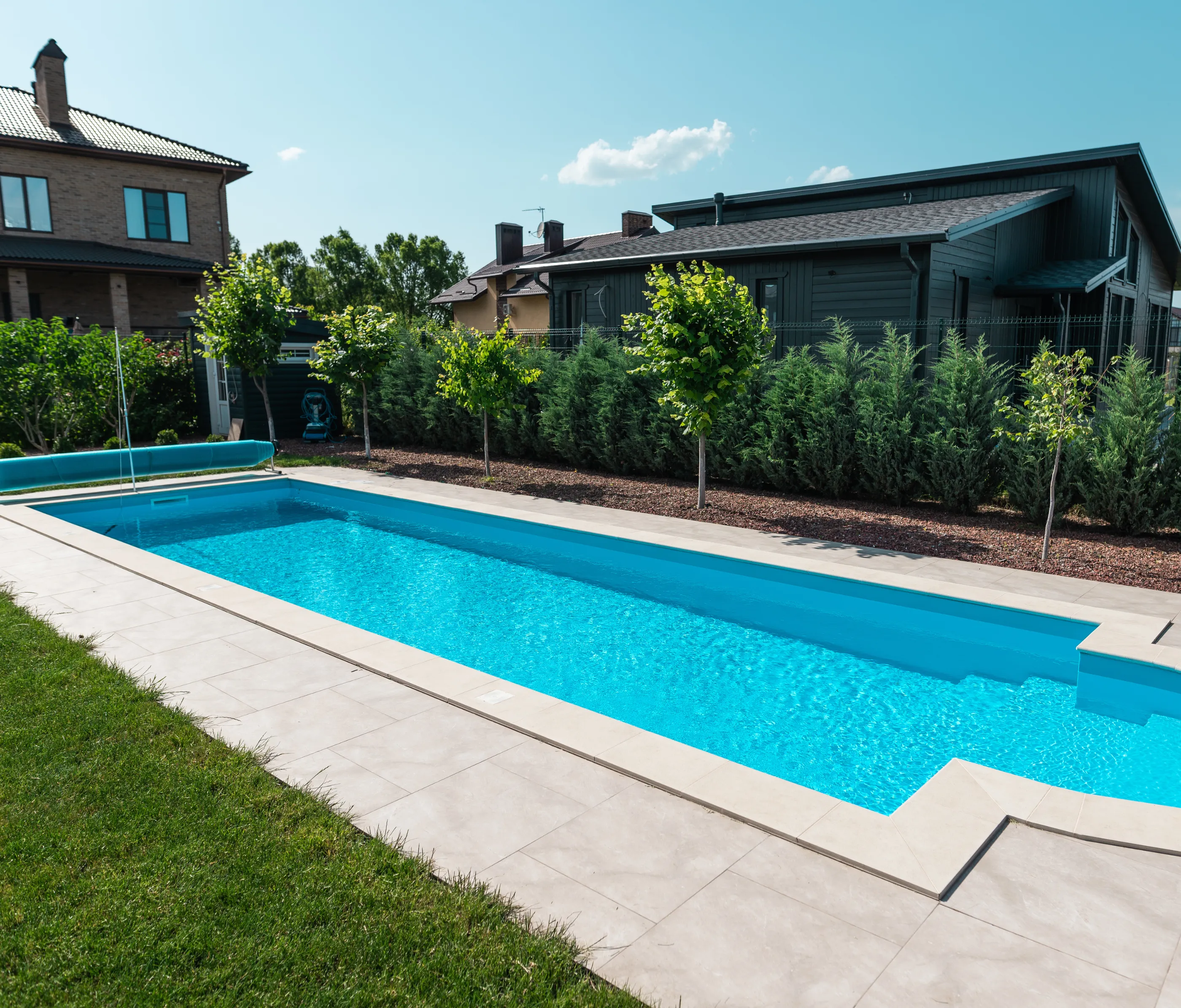 Modern rectangular backyard pool with clean tile deck and fresh landscaping – Dallas Pools Contractor